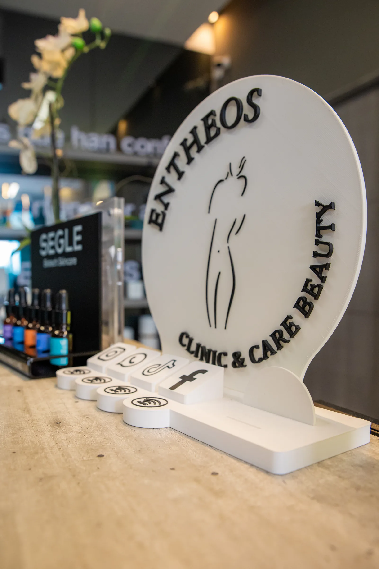 Tótem con el logotipo de Entheos Clinic Care & Beauty en la recepción